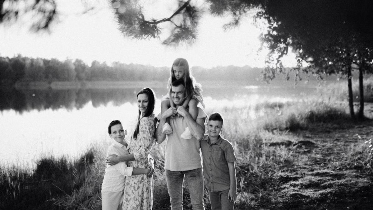 A joyful family enjoying time by the lake in a serene setting.